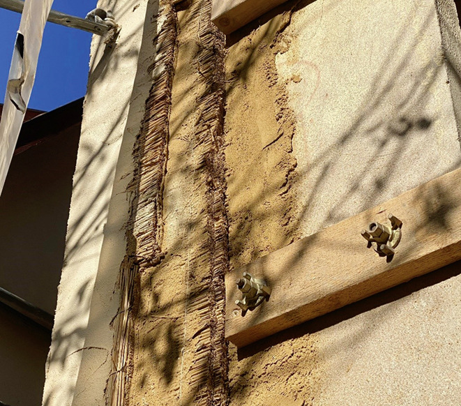 Außendämmung eines Denkmals mit Schilfrohrmatten und Lehm. Durch den Einsatz ökologischer Dämmstoffe wird der CO₂-Fußabdruck der energetischen Modernisierung klein gehalten.