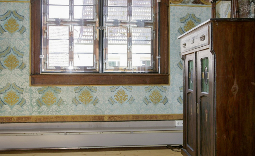 S﻿ockelleistenheizung anstatt Dämmung vor einer Wand mit wertvollen Bemalungen: Die gleichmäßige Erwärmung der Oberflächen schafft ein behagliches Raumklima.