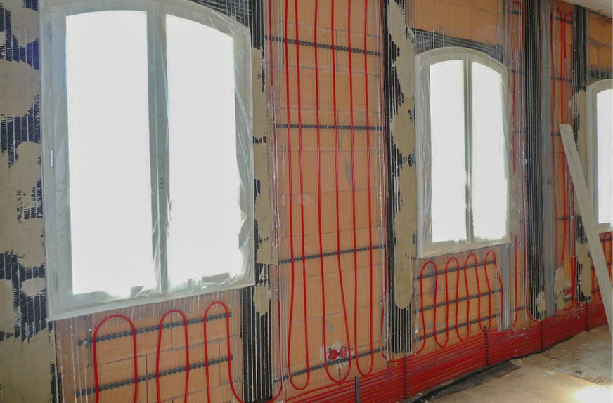 Wandflächenheizung: Im Sockelbereich wurden die Heizschlangen enger geführt, da dort die Wärmeabgabe intensiver sein soll.