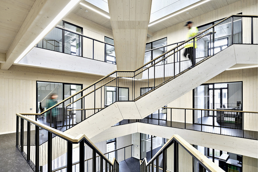 Kommunikationsgeflecht: Damit sich die Mitarbeitenden begegnen, ­kreuzen&nbsp;sich die Treppen im Atrium. Die Lüftungsleitungen für die Büros verlaufen hinter dem Unterzug um das Atrium herum.