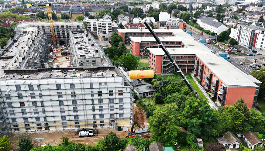 Vier Wohnblöcke in Wagenburgformation bilden das neue Quartier Lück in Köln-Ehrenfeld – hier wird gerade der Pufferspeicher eingehoben.