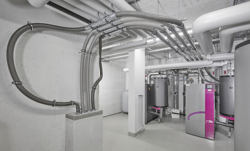 Funktioniert auch im Großen: Von außerhalb des Gebäudes führt eine Füllleitung in den Lagerraum, von dort flexible Befüllschläuche zu den Gewebe­silos. Da bei ihnen die Förderluft staubfrei über den Silodeckel entweicht, kann auf eine zusätzliche Absaugung verzichtet werden. Allerdings ist eine Be- und Entlüftung des Aufstellraumes zwingend erforderlich.