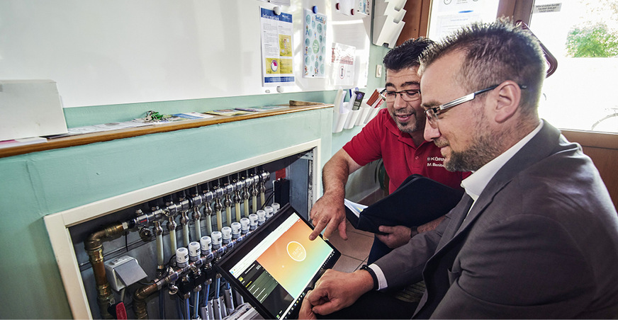 Viega-Verkaufsberater Markus Droisdorf (rechts) und Fachhandwerker Manuel Benitez stellen das neue Regelungssystem für den Heizkreisverteiler ein.