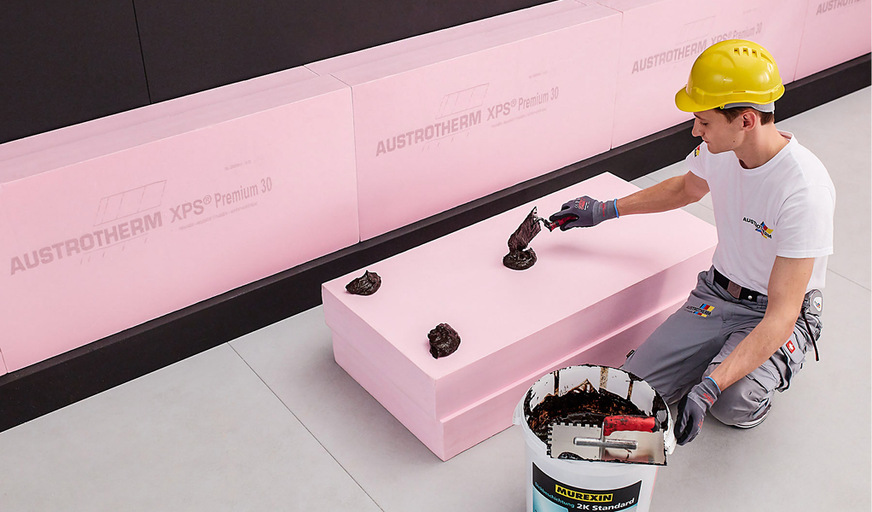 Bei einer Perimeterdämmung mit Lastfall Bodenfeuchte muss die erste Reihe der Dämmstoffplatten an die Hohlkehle angepasst werden. Es genügt, wenn der Kleber, z.B. Bitumenkleber, punktförmig aufgebracht wird.