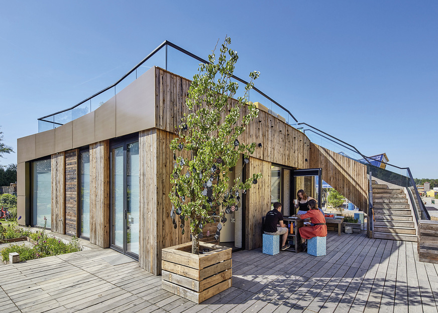 8 Die kombinierten und gleichfarbigen PV- und PVT-Paneele im sogenannten Solargürtel passen zu dem recycelten Holz und fügen sich harmonisch in das Fassadenbild ein.