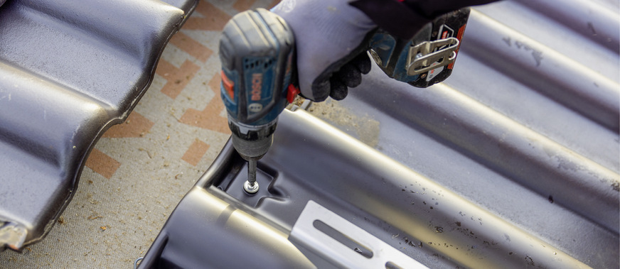 Die Trägerpfannen werden mithilfe von zwei handelsüblichen Spenglerschrauben an der Dachlattung befestigt.