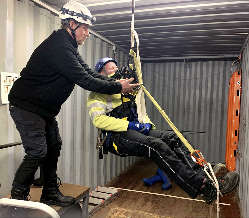 Lehrer Sven Sula hilft einem Schüler beim Aufbau einer Schlinge für die Füße zur&nbsp;Verhinderung des Hängetraumas und beim Einsatz des Rettungsgerätes.