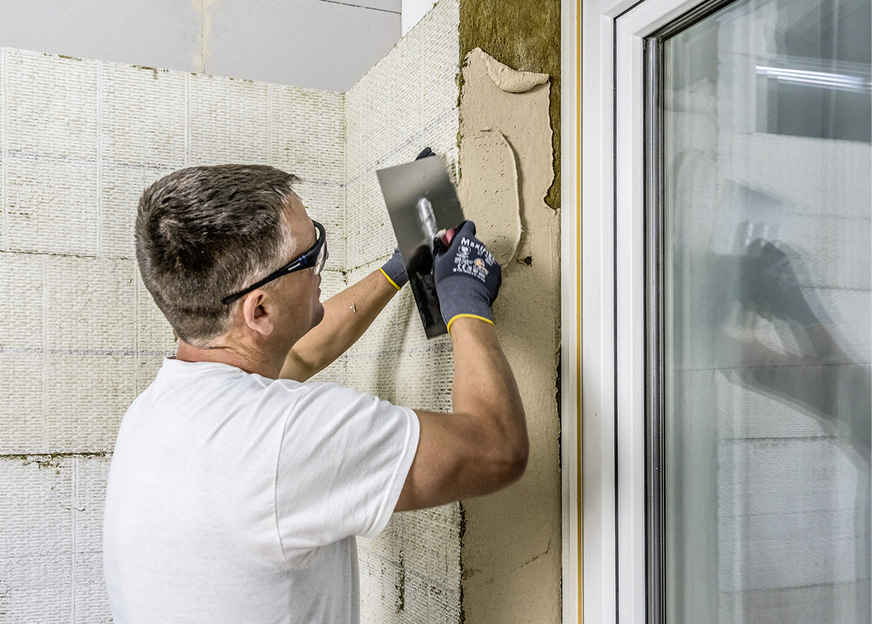 Vorbeschichtete Leibungsplatten werden im Buttering-Floating-Verfahren auf den Dämmstoff aufgebracht.