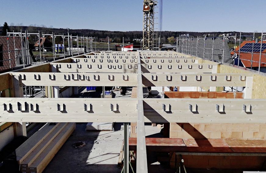 Die neue Tragkonstruktion aus Brettschichtholz-Trägern ersetzt die schweren Stahlbeton-Dachbinder. Sie wurde in die bestehenden Gabellager eingesetzt.