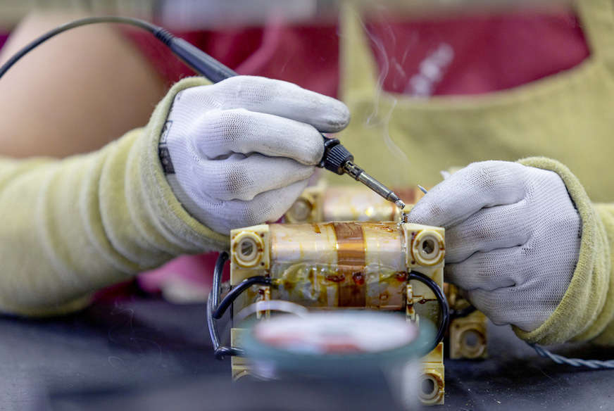 Nachdem die Drosseln zum Trafo zusammengebaut wurden, werden die Ableitungen angelötet. Nach einer weiteren Qualitätskontrolle geht es dann in die Versiegelung.