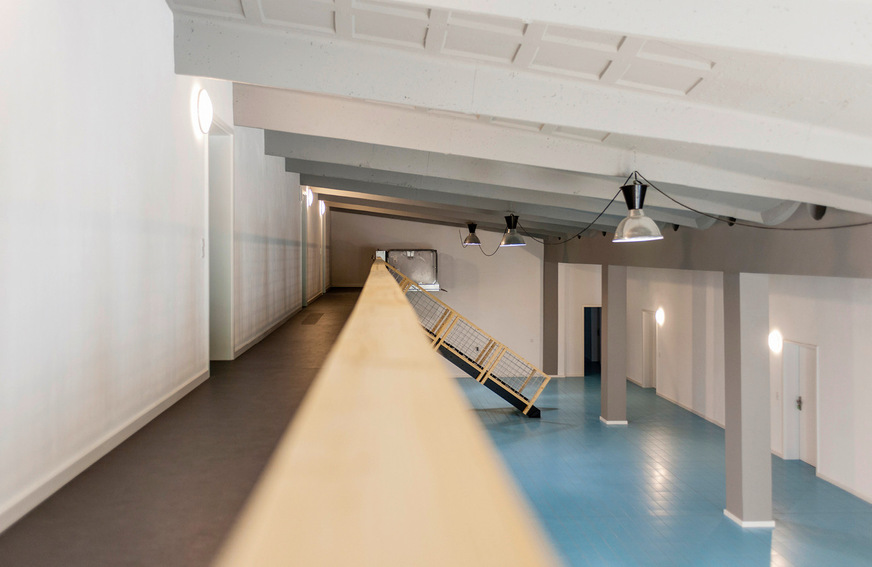 9 In dem großen Foyer, über das die Wohnungen erschlossen werden, finden sich Reminiszenzen an das Volksschwimmbad: blaue Bodenfliesen und ein geretteter Startblock.