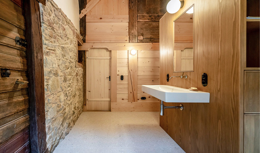 12 Neue Möbel und Einbauten wahren respektvoll Distanz gegenüber der jahrhundertealten Substanz.