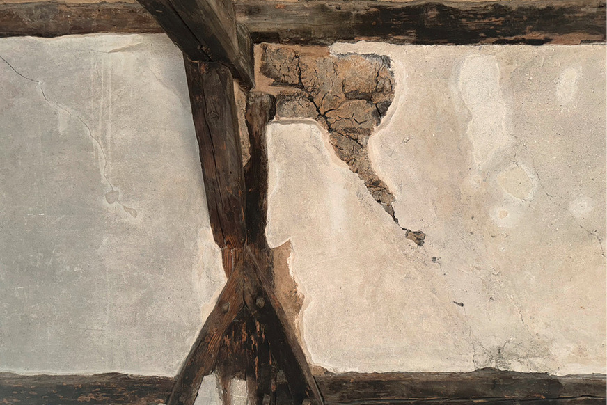 Historischer Giebel mit Lehmausfachung: Die rissigen Oberflächen sind dem Schwindverhalten des Lehms geschuldet. Die Anschlussflanken an die meisten Hölzer wurden im Zuge einer Renovierung mit Lehm nachgebessert, die Ausfachungen mit einem Kalkputz überformt.