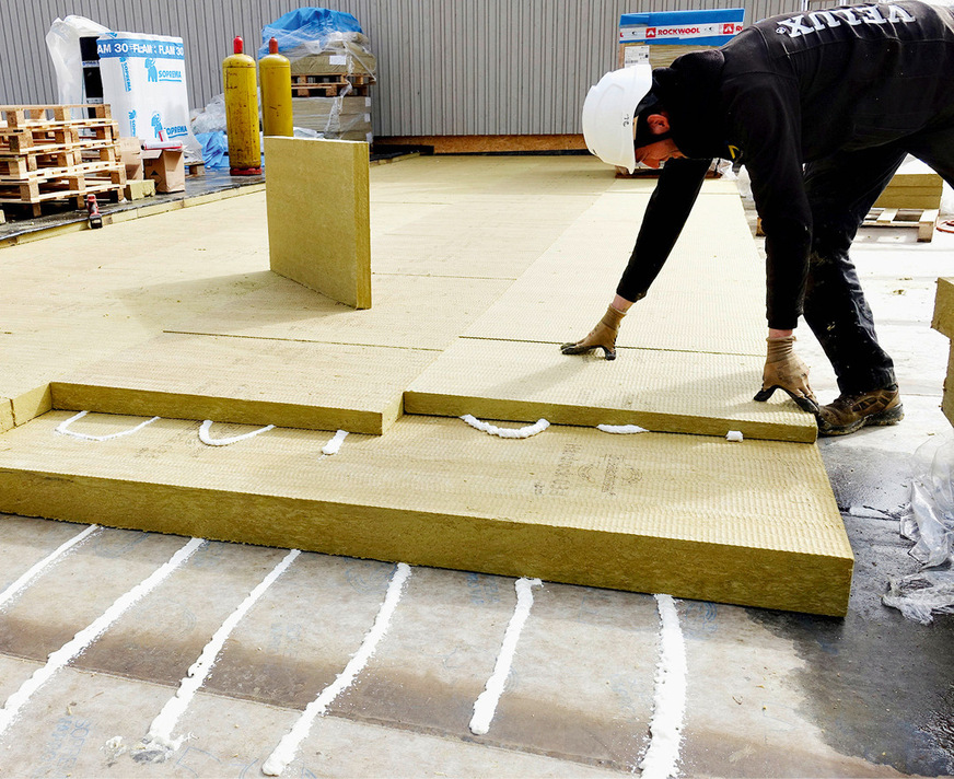 Zur Wärmedämmung haben die Dachdecker erst die Hardrock-Dämmplatten auf der Elastomerbitumen-Dampfsperrbahn verklebt.