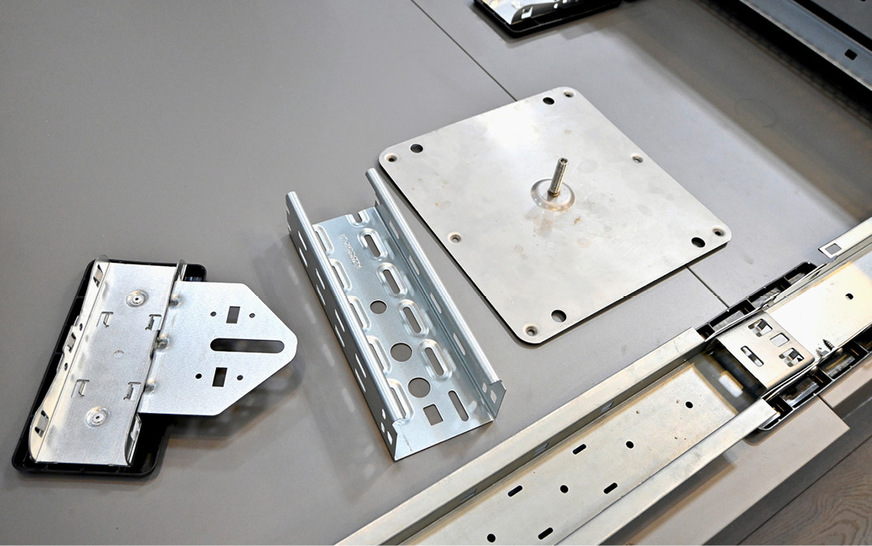 Mit dem neuen Bodenschuh (links) kann der Installateur mit dem Fast Flat von SL Rack Kabelkanal und Ankerplatte anbinden. Rechts am Verbinder sind die Blitzstromschrauben zu sehen.