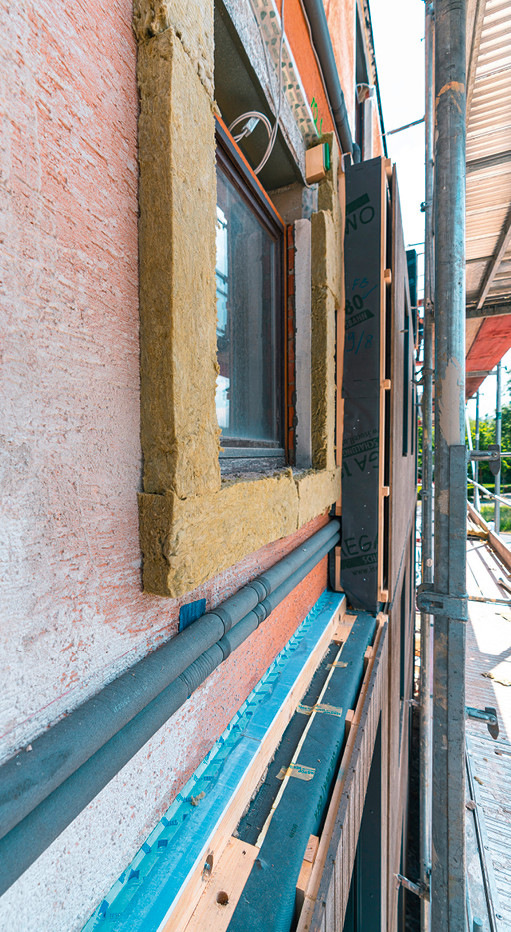 11 Montage der Dämm-Brand­riegel und der Heizverteilrohre an der Fassade