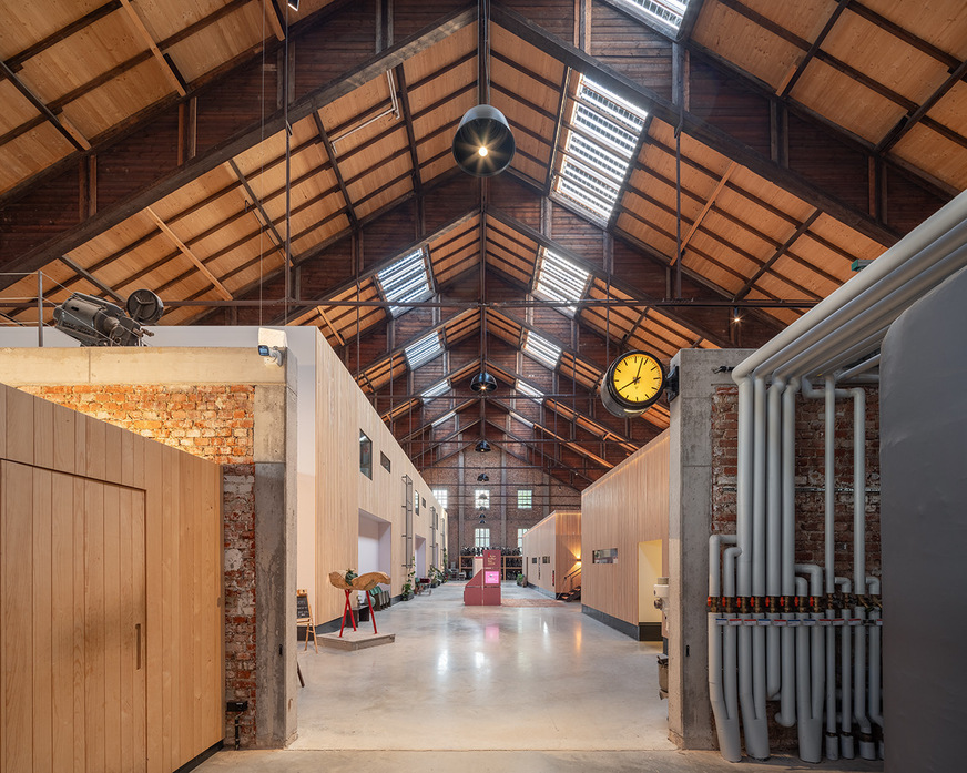 Holzoptik harmoniert mit den Rohren des vernetzten Gesamtsystems. Blick nach hinten, in Richtung Wohnungen.