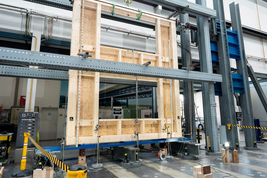 Eine zweigeschossige Hauswand mit Fensteröffnungen wird kontrolliert unter Druck gesetzt.