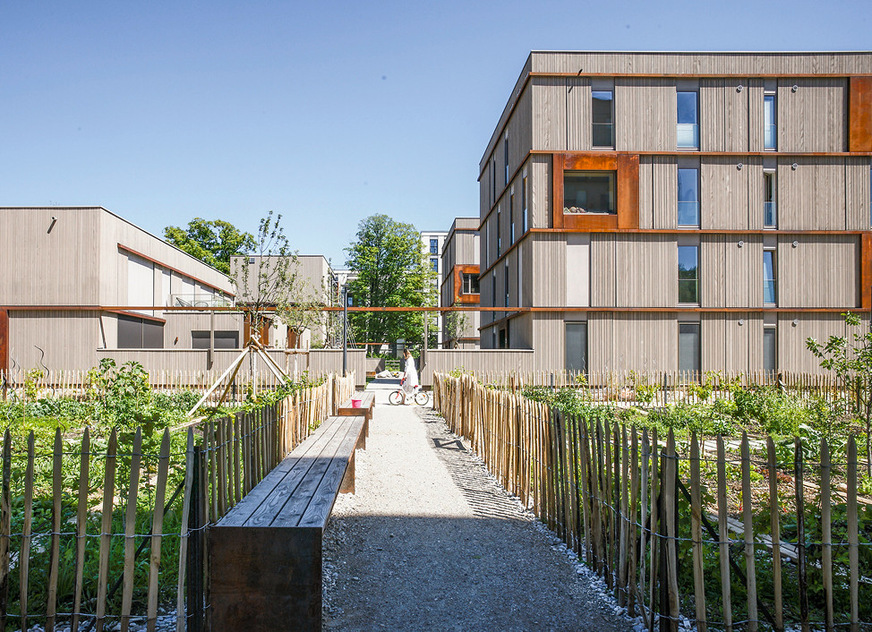 Bei der Holzbausiedlung im Münchner Prinz-Eugen-Park vermeidet eine Kombination aus außenliegender Verschattung, hoher Speichermasse, optimierten Fensterflächen und natürlicher Nachtlüftung die Überhitzung der Innenräume.