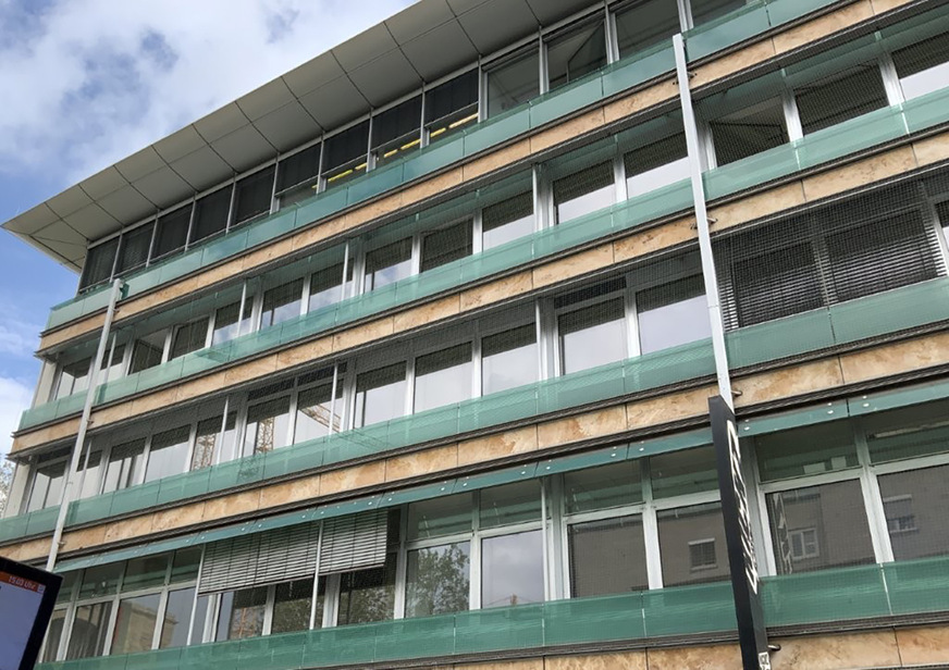 Alu-Glas-Elementfassade mit vorgesetzter Ganzglasbrüstung an einem Bestandsgebäude in Stuttgart-Mitte.