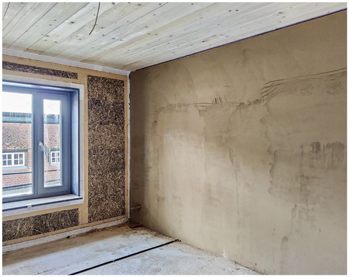 Die strohgedämmten Außenwände sind innenseitig mit einem Lehmputz überzogen.