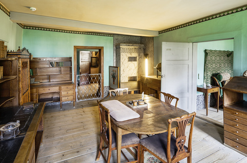 5 Blick v﻿om Arbeitszimmer Goethes in sein unbeheiztes Schlafzimmer mit Wandteppich (rechts): Der Kachelofen an der Rückwand des Arbeitszimmers war n﻿ach dem Ofen in der Küche die am stärksten genutzte Feuerstelle im Gebäude.