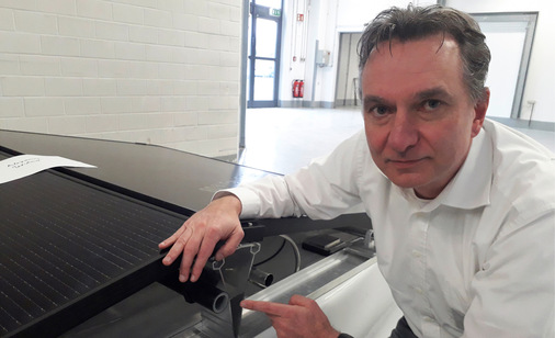 Wilhelm Stein erläutert die Technik des PVT-Kollektors von Sunmaxx. Der Wärmetauscher verschwindet hinter dem Photovoltaikmodul.