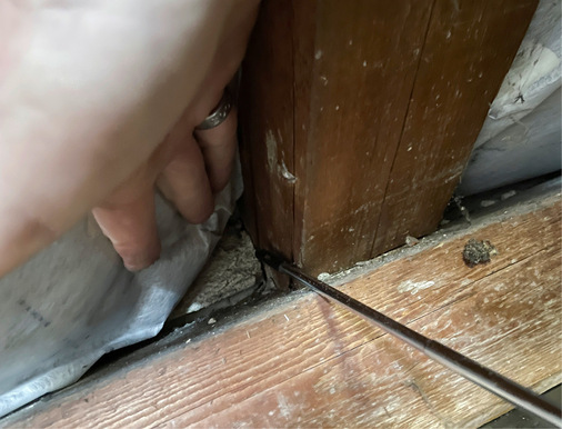 Ausführungsfehler im Dachgeschoss des Hauses aus den 1920ern: An der Fußpfette kann die Dampfbremsfolie mit der Hand beiseitegeschoben werden, Anpressleisten am Sparren und Abdichtung der Sparrenauflage fehlen.