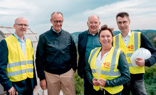 Anfang Juli auf dem Baufeld des Windparks Sundern vor Baggerschaufel, von links nach rechts: Holger Böse, städtischer Fachbereichsleiter Stadtentwicklung, Bundeskanzler Friedrich Merz, Bürgermeister Klaus-Rainer Willeke, Erste Beigeordnete Jacqueline Bila und Kämmerer Michael Stratmann, der auch Geschäftsführer der Sundern Energie GmbH ist.