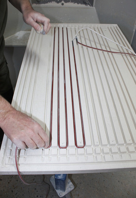 Einlegen des Heizdrahts in die Kanäle, die auf der Rückseite des Steins ­eingefräst wurden.