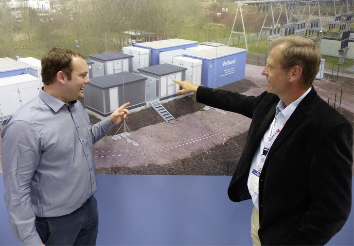 Ulrich Bürger, Geschäftsführer von Eco Stor, mit Hans Urban (rechts) vor einer Projektwand auf der Intersolar 2022.