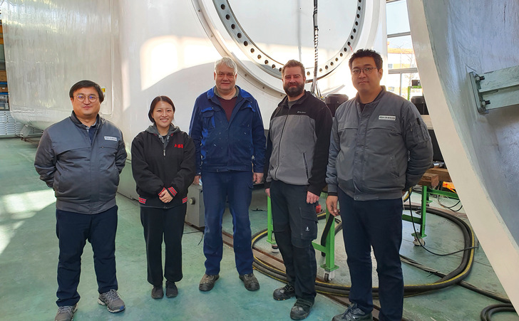 Thorsten Spehr, 3. v. l., mit Kollegen und Kunden von Hanjin und der neuen von Idaswind entworfenen Turbine im Hintergrund in einer Produktionshalle in Südkorea.
