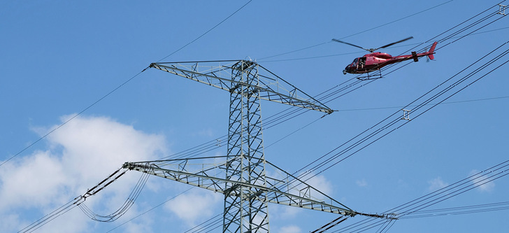 Umfassendes Monitoring: Per Helikopter wird geprüft, ob die Leiterseile, Isolatoren und Armaturen in einem einwandfreien Zustand sind.
