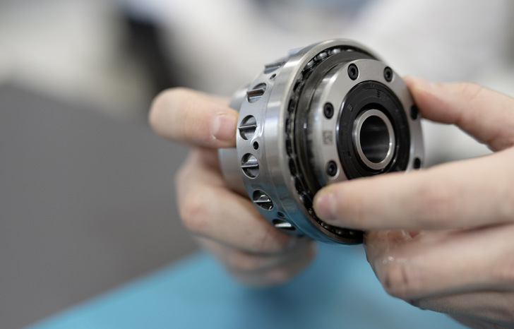 Yaw-Stellgetriebe mit Kolben­antrieb, hier nicht in Windturbinen­größe. Drehen die Hände den Antrieb ­weiter, schiebt der interne Mecha­nismus einen Teil der Kolben mit den hier im Ansatz sichtbaren Zähnen nach außen, während die anderen nach innen verschwinden. Dann ­gehen die ausgefahrenen ­Zähne ­zurück und die anderen schieben sich nach außen. Die ­Zähne drehen so jeweils das Hohlrad leicht voran.