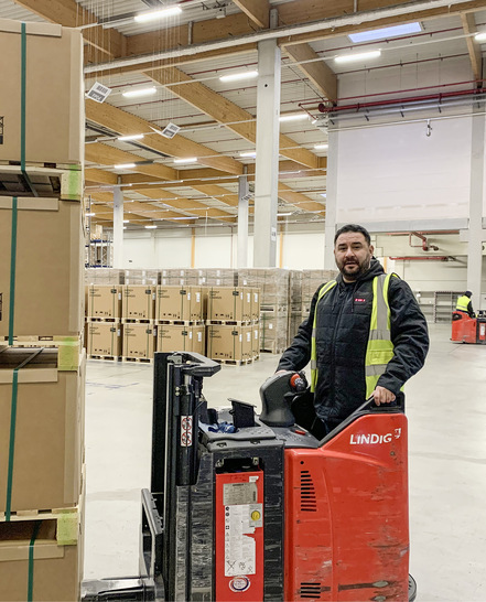 Staplerfahrer mit Thermoweste in der Logistikhalle von SMA.