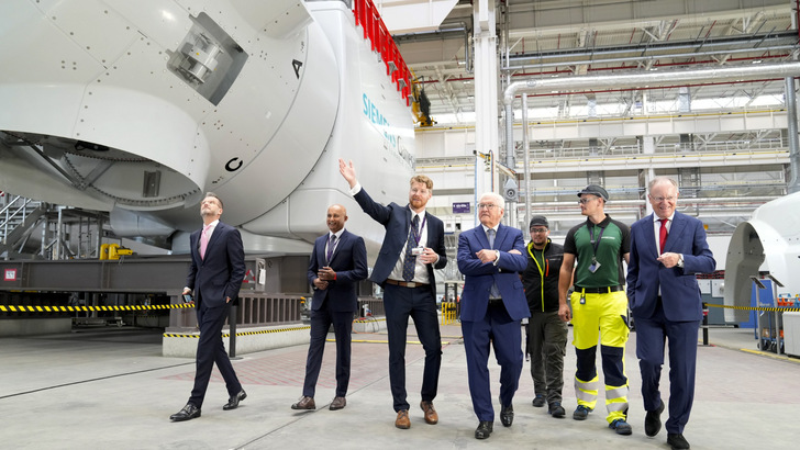 Politikerbesuch 2024 vor Maschinenhäusern der SG 14-222/236 DD: Offshore-Anlagen-Fertigung im Werk Cuxhaven bei Siemens Energy mit Bundespräsident Frank-Walter Steinmeier (Mitte), Niedersachsens Ministerpräsident Stephan Weil (rechts) und Werksleiter Kristoffer Mordhorst (3. von links) sowie Werksmitarbeitern