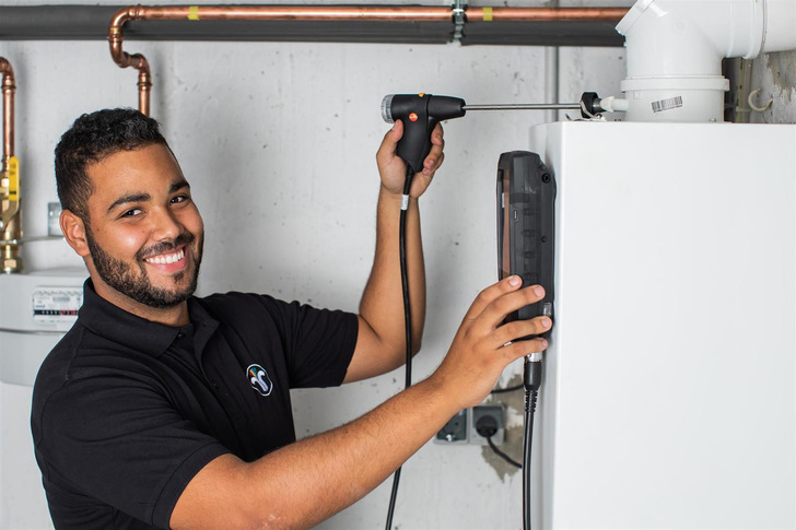 Schornsteinfeger misst Abgasemissionen einer Heizungsanlage.