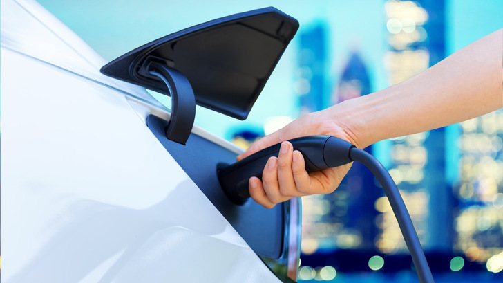 Person charging an electric vehicle