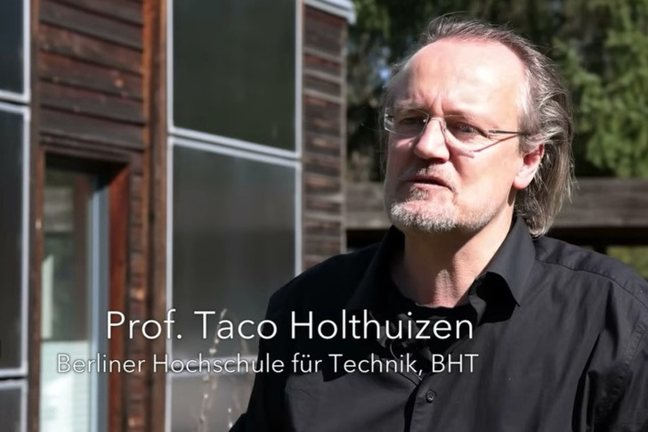 Ein Mann mit Brille und schwarzem Hemd steht draußen vor einem Gebäude. Text: "Prof. Taco Holthuizen, Berliner Hochschule für Technik. - © Screenshot