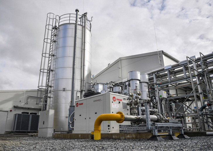 Industrieanlage mit Metalltanks, Maschinen und Rohren auf einer Kiesfläche unter einem bewölkten Himmel. - © Foto: Florian Miedl - Stadtwerke Wunsiedel