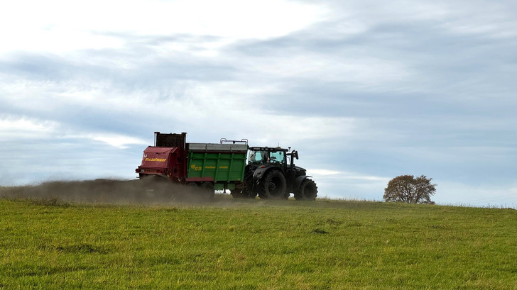 Ein Landwirt bringt gemahlenen Basalt auf seinem Feld aus.