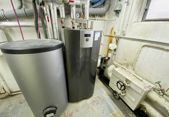 Wärmepumpe und Pufferspeicher kompakt im Heizkeller installiert.