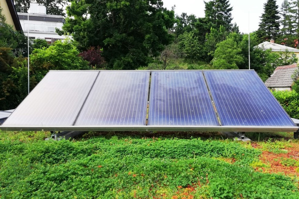 Auf einem begrünten Dach montierte Sonnenkollektoren.