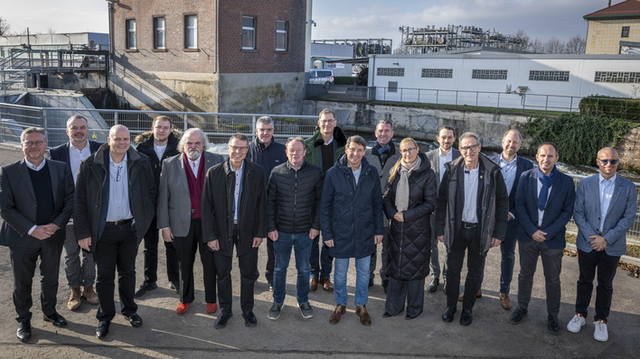 Die Vertreter von EnBW und Kommunen vor dem Wasserkraftwerk Rheinhausen.