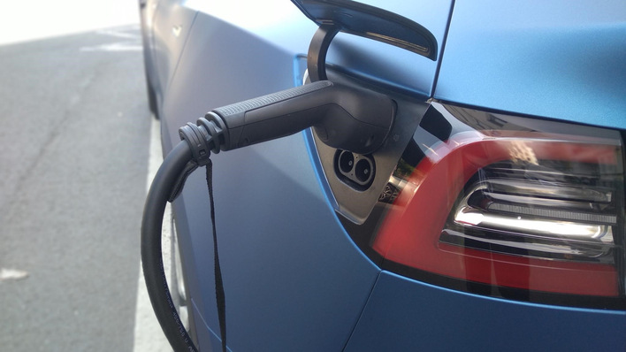 Elektroauto wird an einer Station aufgeladen, Nahaufnahme von Ladeanschluss und Kabel. - © Milena Wolf