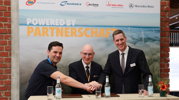 Nordex-CEO José Luis Blanco, UKA-Geschäftsführer Gernot Gauglitz, Max-Bögl-Vorstandsvorsitzender Stefan Bögl (von links) beim Handschlag bei der Husum Wind 2025 nach der Vertragsunterzeichnung für Windpark Papenburg zur Direktversorgung von Mercedes Benz