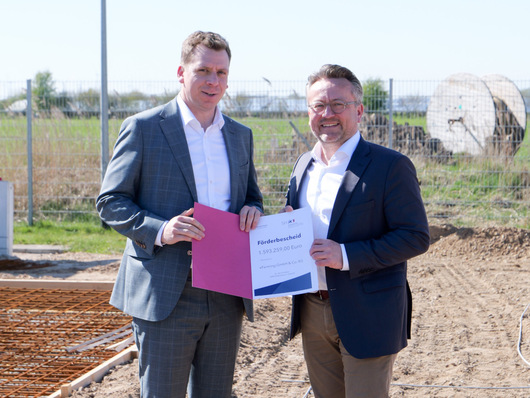 Staatssekretär Joschka Knuth (l.) übergibt in Bosbüll den Förderbescheid des Landes an André Steinau, Geschäftsführer von eFarming.